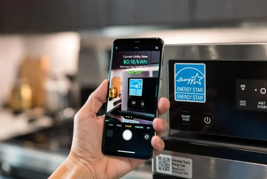 A high-resolution, close-up shot of a hand holding a modern smartphone to scan a QR code on a smart oven